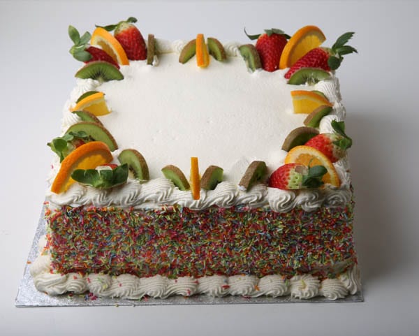 Fruit and hundreds and thousands decorated large celebration cake by Quigleys cafe, bakery and deli