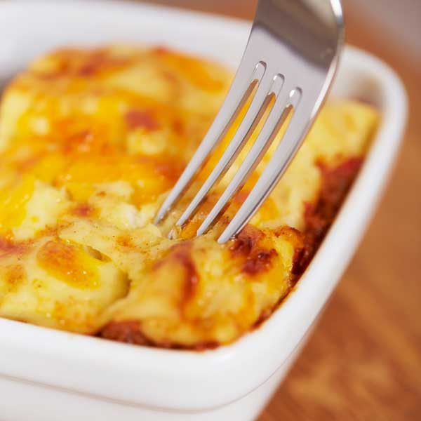 Lasagne in a white dish with fork from Quigleys cafe, bakery and deli